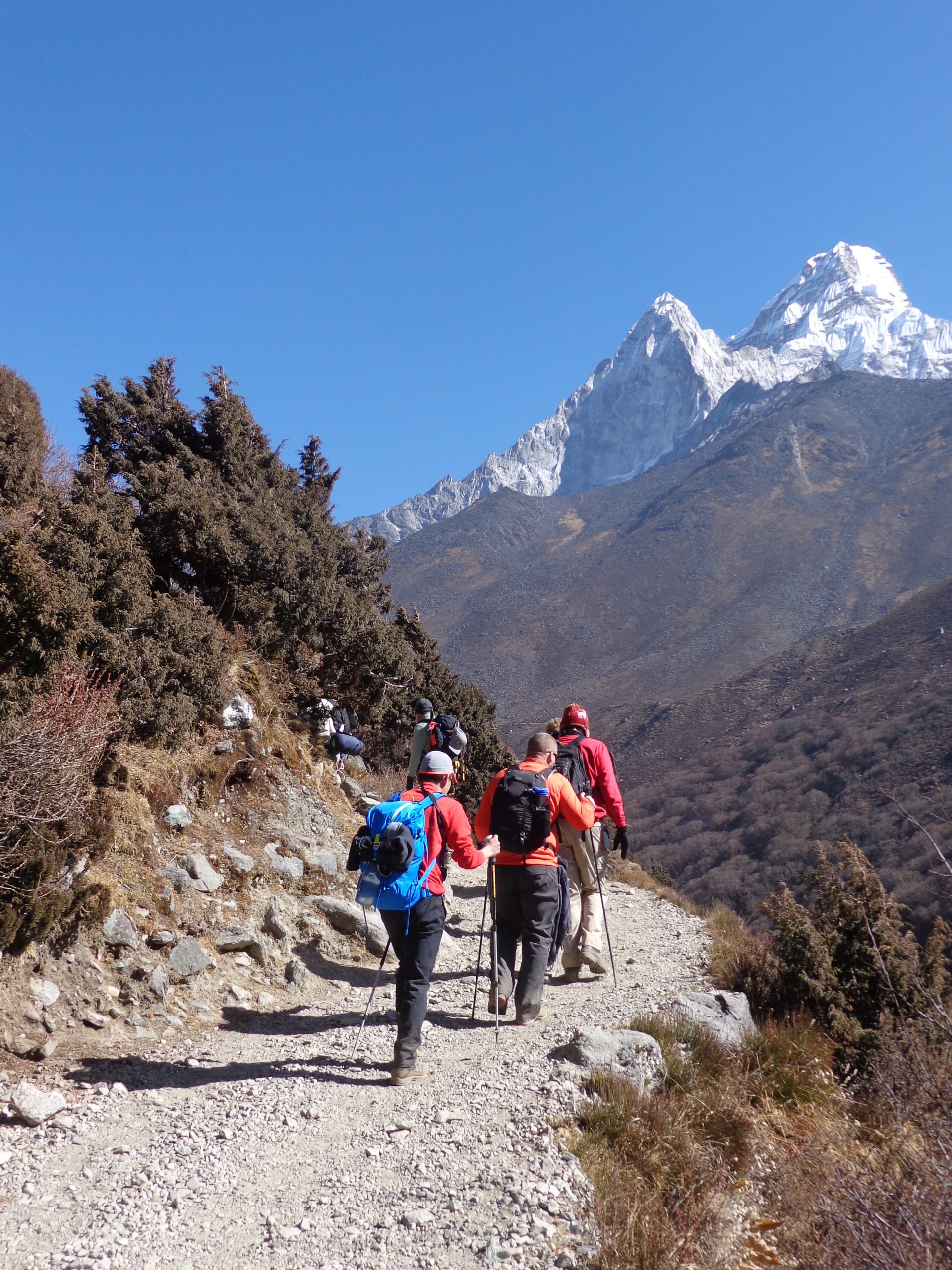 Trekkers on the trail with Ama Dablam visible around the corner, Nepal