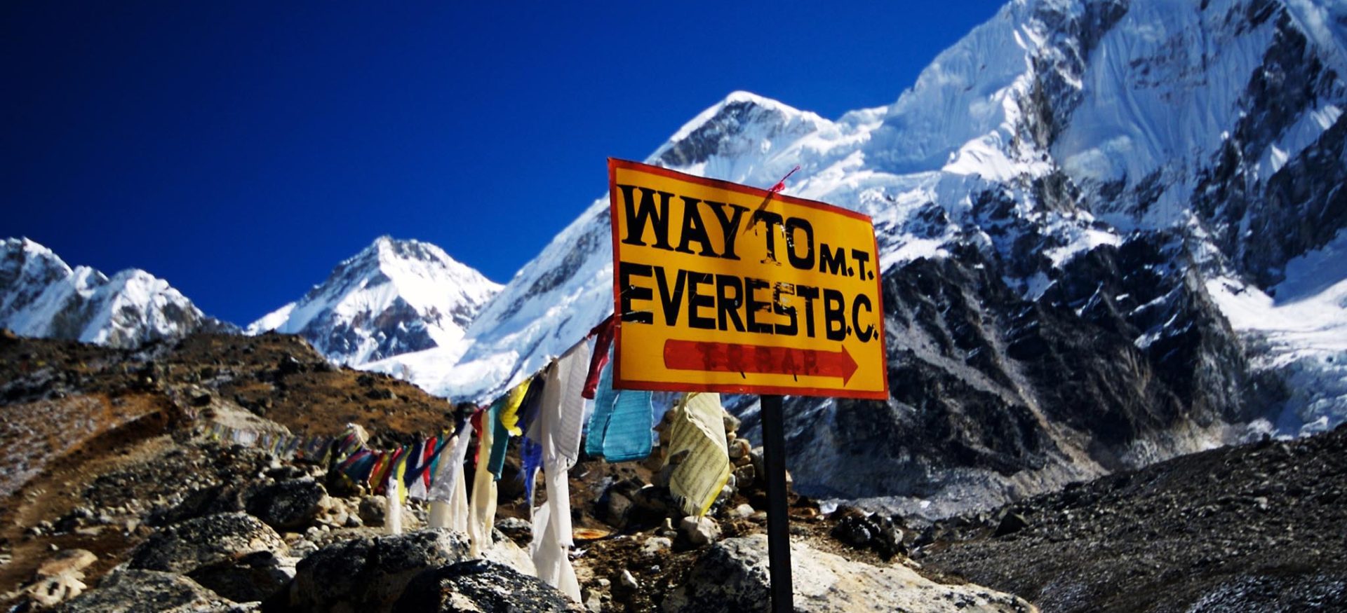 Sign post on the trail to Everest Base Camp with Mountain peak visible in the Khumbu region of Nepal
