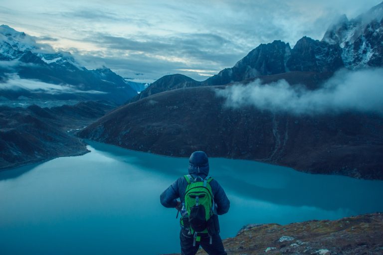 Trekkers on the trail above Gokyo Lakes with Himalayan peaks visible in the Khumbu region