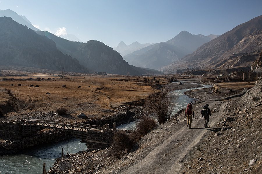 Mountainkick trekkers walking the manag valley across marsyangdi river