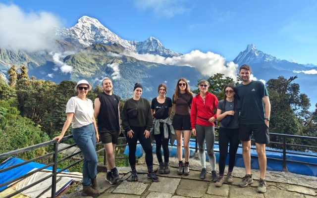 Group of trekkers posing infront of fishtail mountain