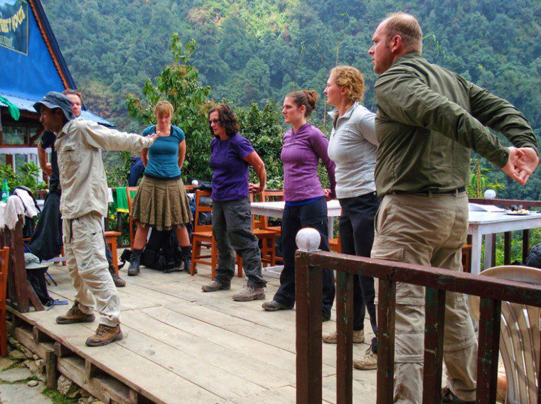 Trekker stretching on a mountain trail in Nepal
