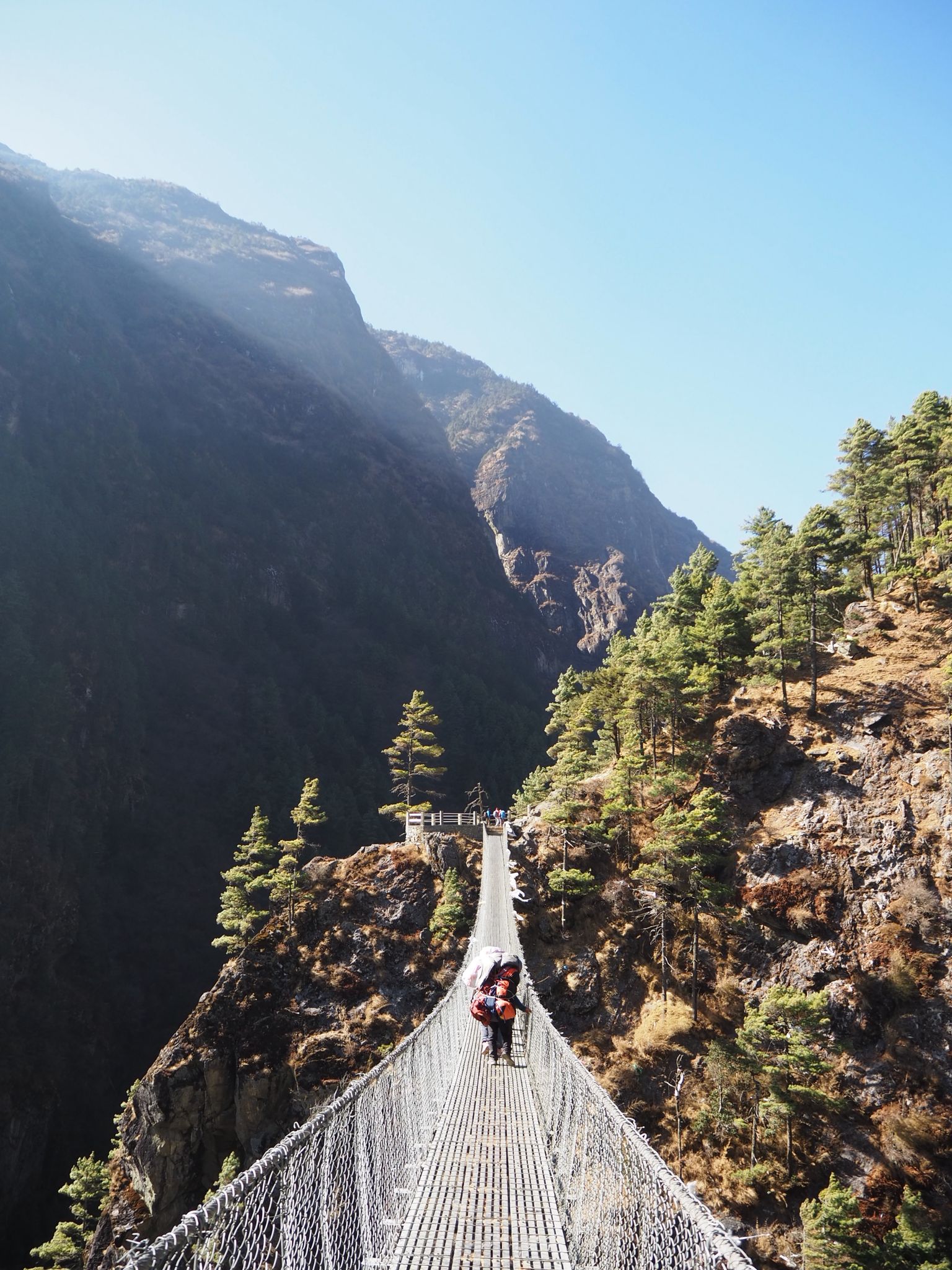 Trekkers crossing a suspension bridge on the way to Namche Bazaar