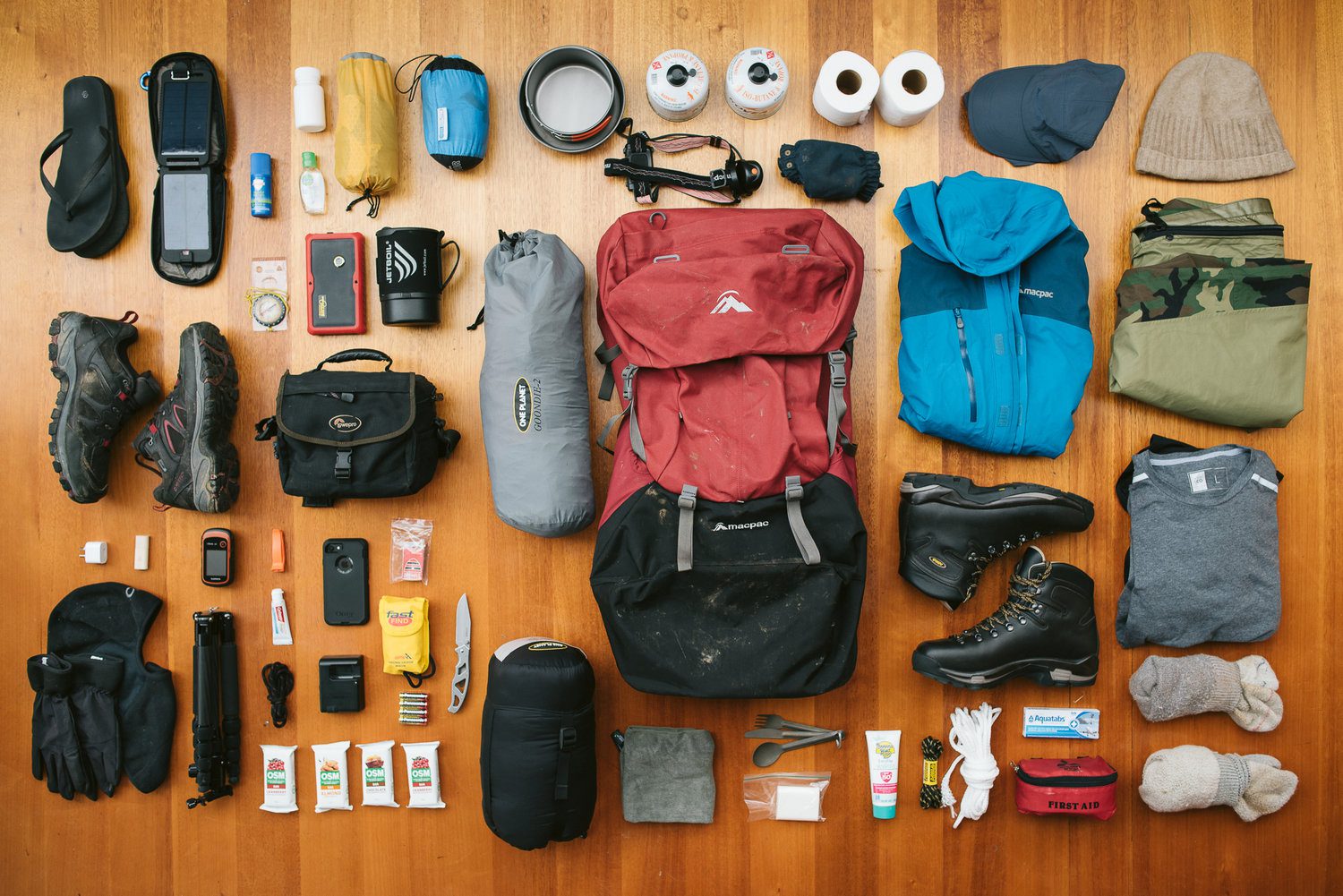 Trekking gear laid out for packing a duffel bag