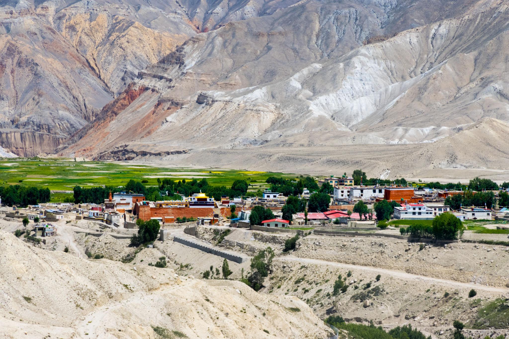 Green fields and dry hills in Upper Mustang in summer